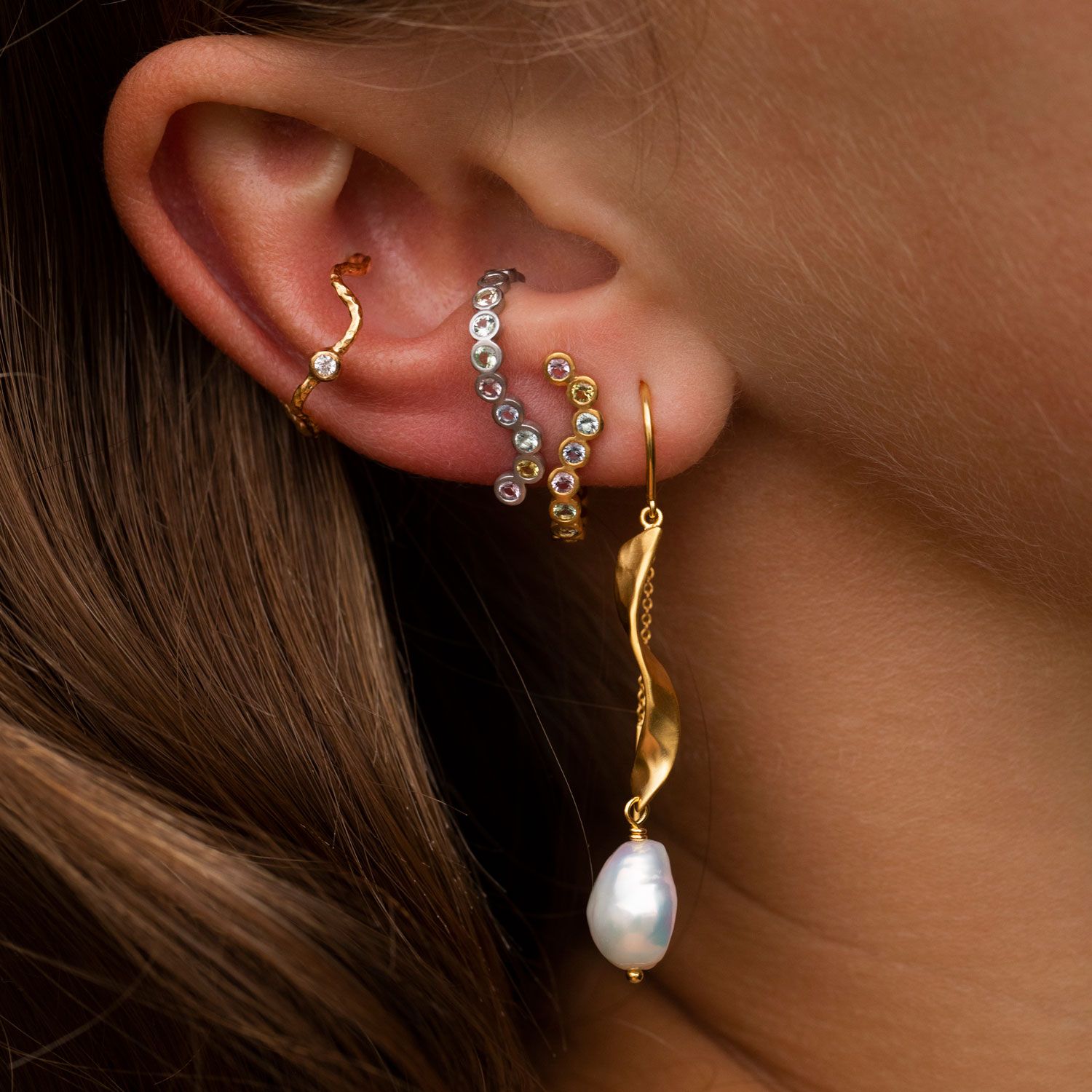 Stine A LONG TWISTED WITH BAROQUE PEARL Ørering 1271-02-S Smuk ørering med en lang flot twisted plade der afsluttes elegant med en hvid ferskvandsperle og en kæde på bagsiden.